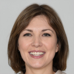 Joyful white adult female with medium  brown hair and grey eyes