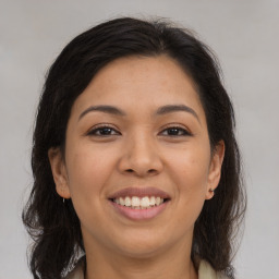 Joyful latino young-adult female with medium  brown hair and brown eyes