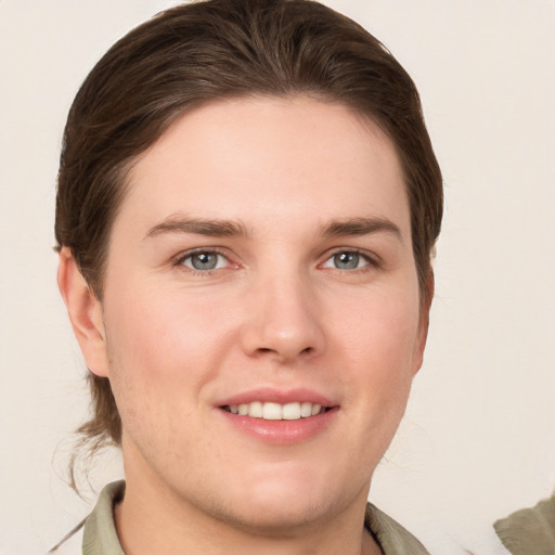 Joyful white young-adult male with medium  brown hair and grey eyes