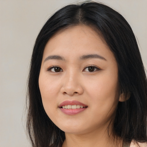 Joyful asian young-adult female with long  black hair and brown eyes