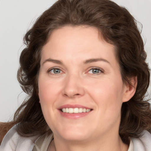 Joyful white young-adult female with medium  brown hair and green eyes