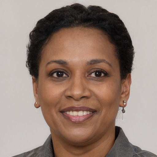Joyful black adult female with short  brown hair and brown eyes