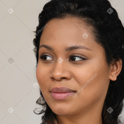 Joyful black young-adult female with long  black hair and brown eyes