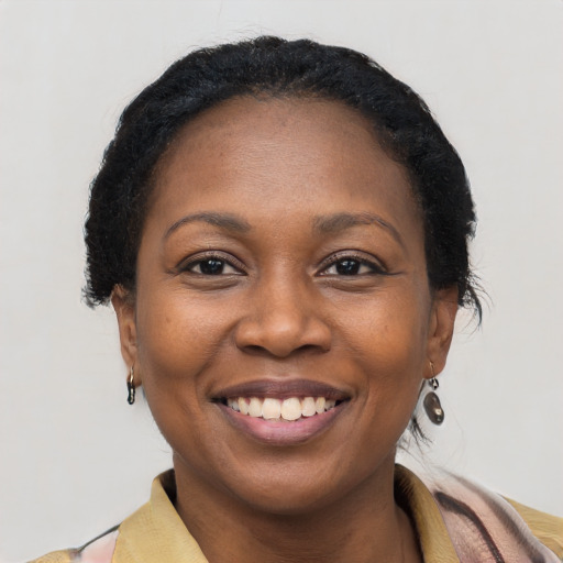 Joyful black adult female with short  brown hair and brown eyes