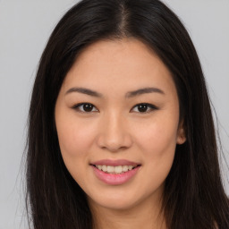 Joyful asian young-adult female with long  brown hair and brown eyes