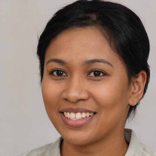 Joyful latino young-adult female with medium  brown hair and brown eyes