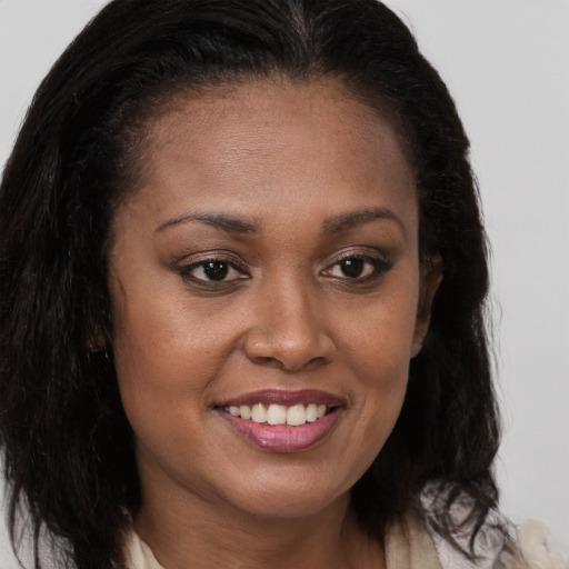 Joyful black young-adult female with long  brown hair and brown eyes