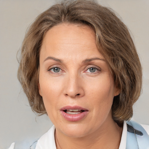 Joyful white adult female with medium  brown hair and grey eyes