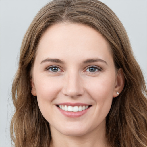 Joyful white young-adult female with long  brown hair and grey eyes