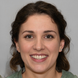 Joyful white young-adult female with medium  brown hair and green eyes