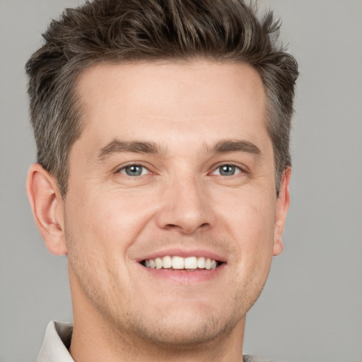 Joyful white adult male with short  brown hair and grey eyes