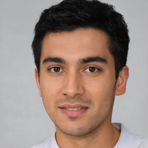 Joyful latino young-adult male with short  black hair and brown eyes