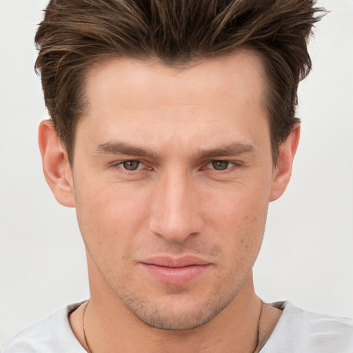 Joyful white young-adult male with short  brown hair and grey eyes