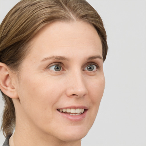 Joyful white young-adult female with medium  brown hair and grey eyes