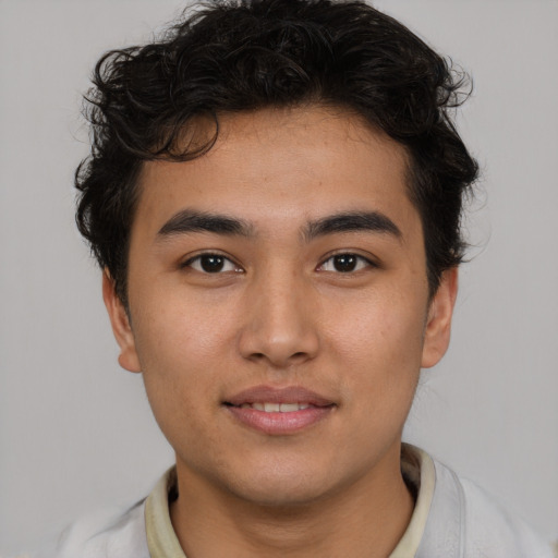 Joyful latino young-adult male with short  brown hair and brown eyes