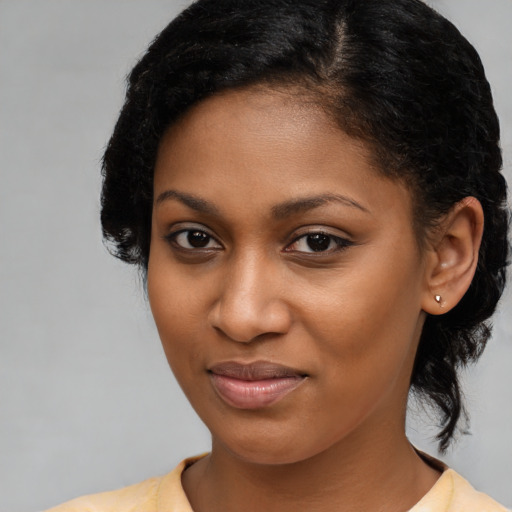 Joyful black young-adult female with medium  brown hair and brown eyes