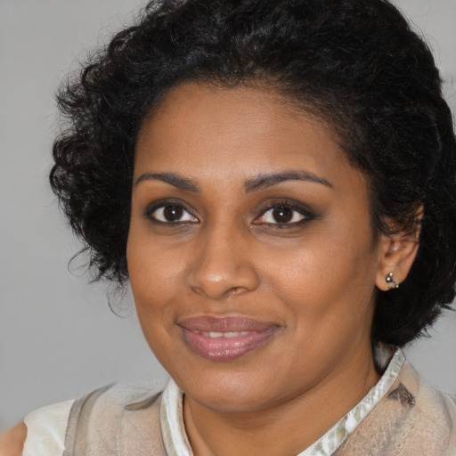 Joyful black young-adult female with medium  brown hair and brown eyes