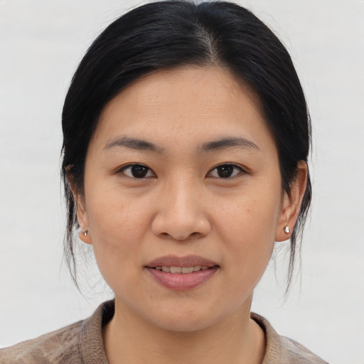 Joyful asian young-adult female with medium  brown hair and brown eyes