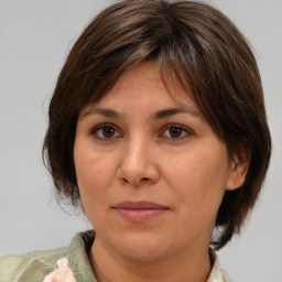 Joyful white adult female with medium  brown hair and brown eyes