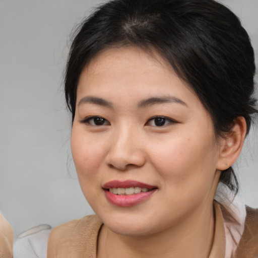 Joyful asian young-adult female with medium  brown hair and brown eyes