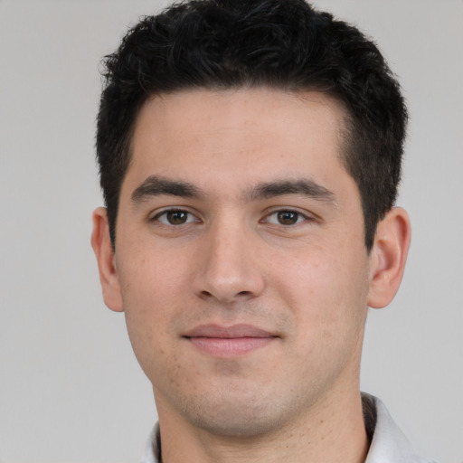 Joyful white young-adult male with short  black hair and brown eyes