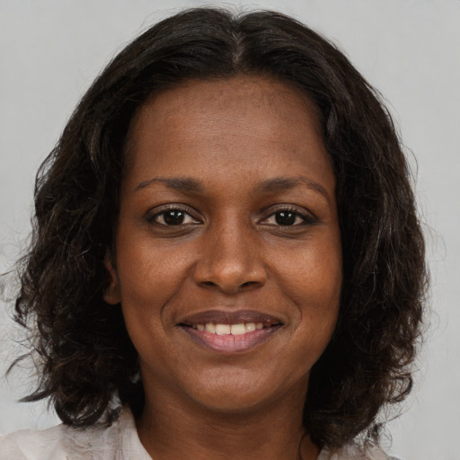 Joyful black young-adult female with medium  brown hair and brown eyes