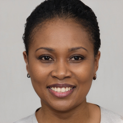 Joyful black young-adult female with short  black hair and brown eyes