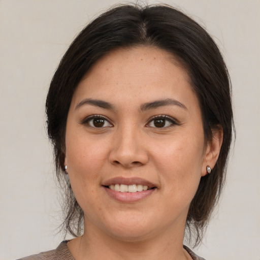 Joyful latino young-adult female with medium  brown hair and brown eyes