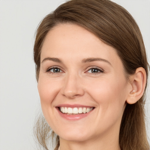 Joyful white young-adult female with long  brown hair and brown eyes