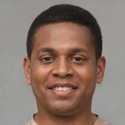 Joyful latino young-adult male with short  brown hair and brown eyes