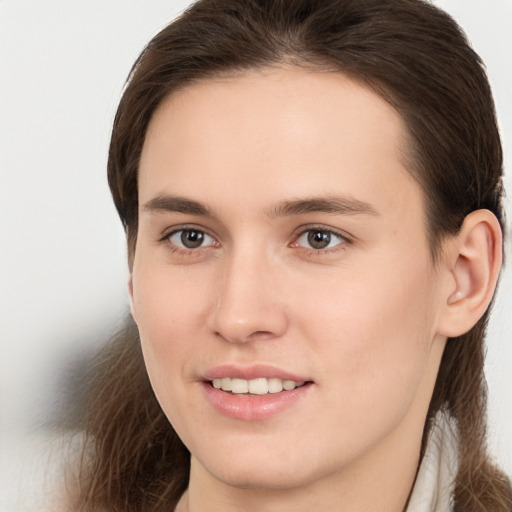 Joyful white young-adult female with long  brown hair and brown eyes