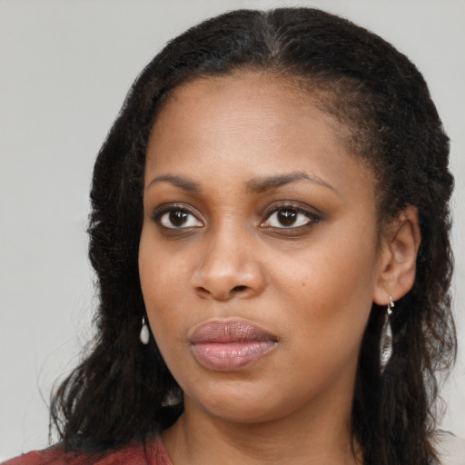 Joyful black young-adult female with long  brown hair and brown eyes