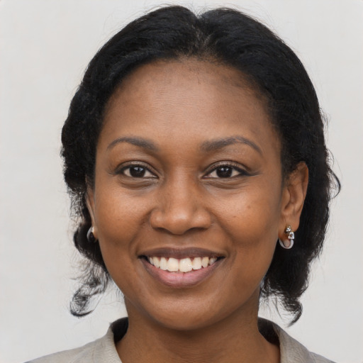 Joyful black young-adult female with long  black hair and brown eyes