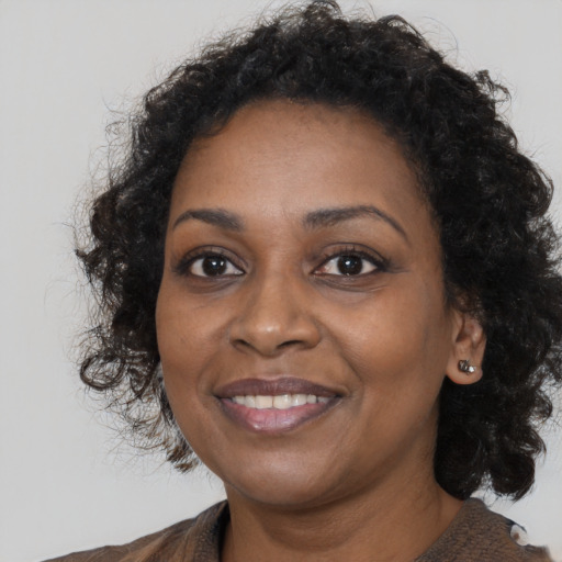 Joyful black young-adult female with medium  brown hair and brown eyes