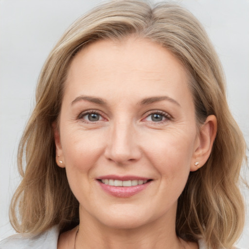 Joyful white adult female with medium  brown hair and blue eyes