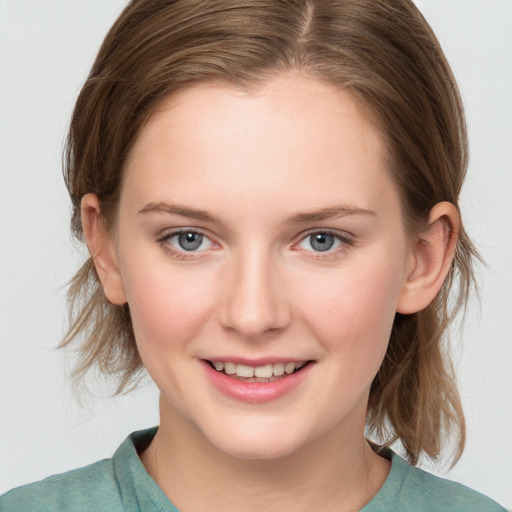 Joyful white young-adult female with medium  brown hair and blue eyes