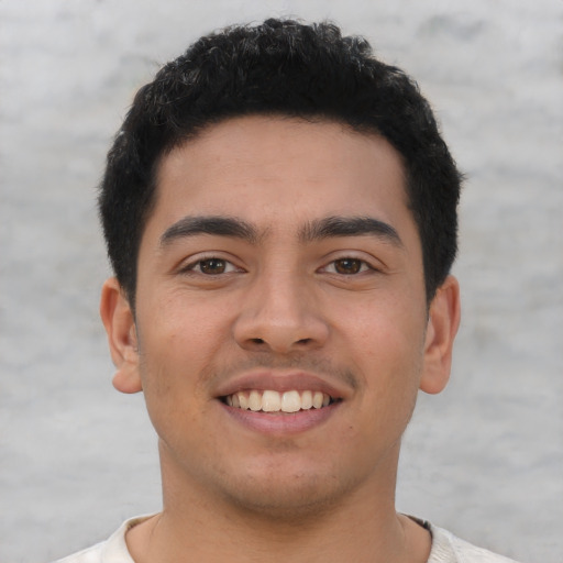 Joyful latino young-adult male with short  black hair and brown eyes