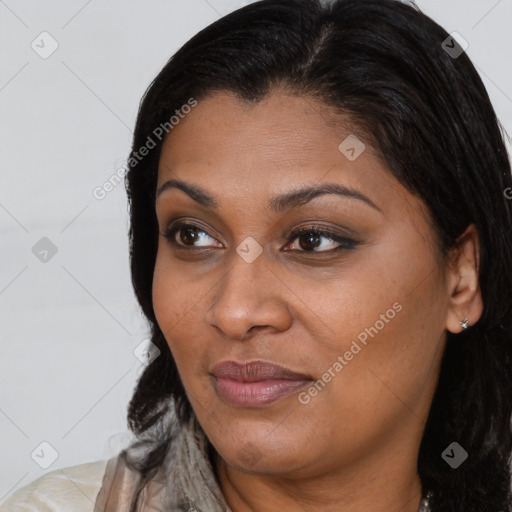 Joyful black young-adult female with long  brown hair and brown eyes