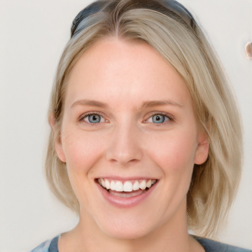 Joyful white young-adult female with medium  brown hair and blue eyes