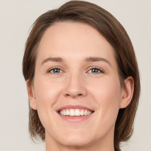 Joyful white young-adult female with medium  brown hair and green eyes