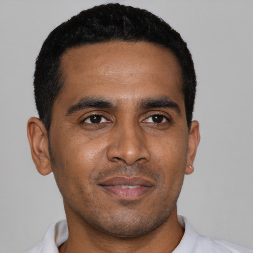 Joyful black young-adult male with short  black hair and brown eyes