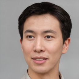 Joyful asian young-adult male with short  brown hair and brown eyes