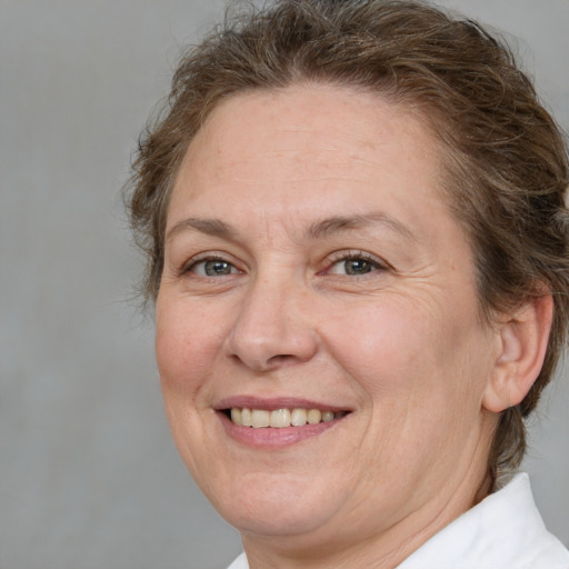 Joyful white adult female with medium  brown hair and grey eyes