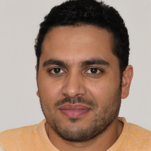 Joyful latino young-adult male with short  brown hair and brown eyes