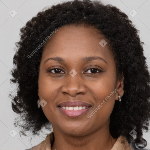 Joyful black adult female with long  brown hair and brown eyes