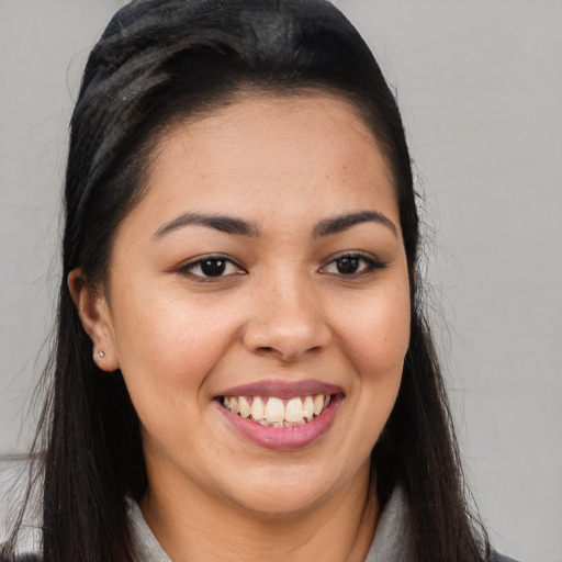 Joyful latino young-adult female with long  brown hair and brown eyes