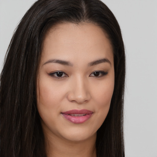 Joyful asian young-adult female with long  brown hair and brown eyes