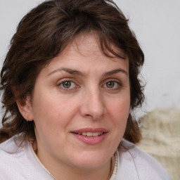 Joyful white adult female with medium  brown hair and blue eyes