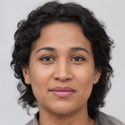 Joyful latino adult female with medium  brown hair and brown eyes