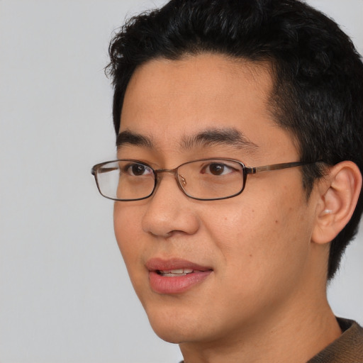 Joyful asian adult male with short  black hair and brown eyes